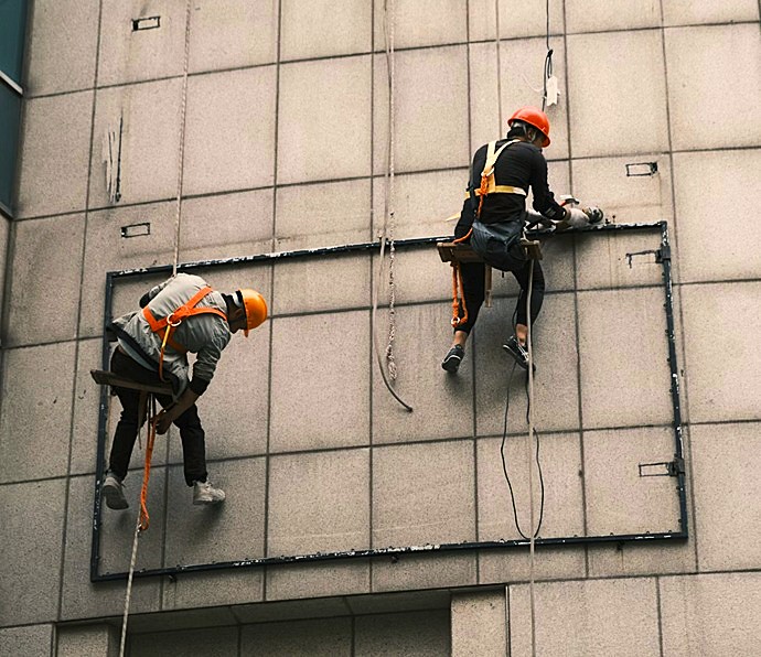 Equipo de técnicos especialistas realizando intervención coordinada en fachada mediante trabajos verticales sin andamios.
