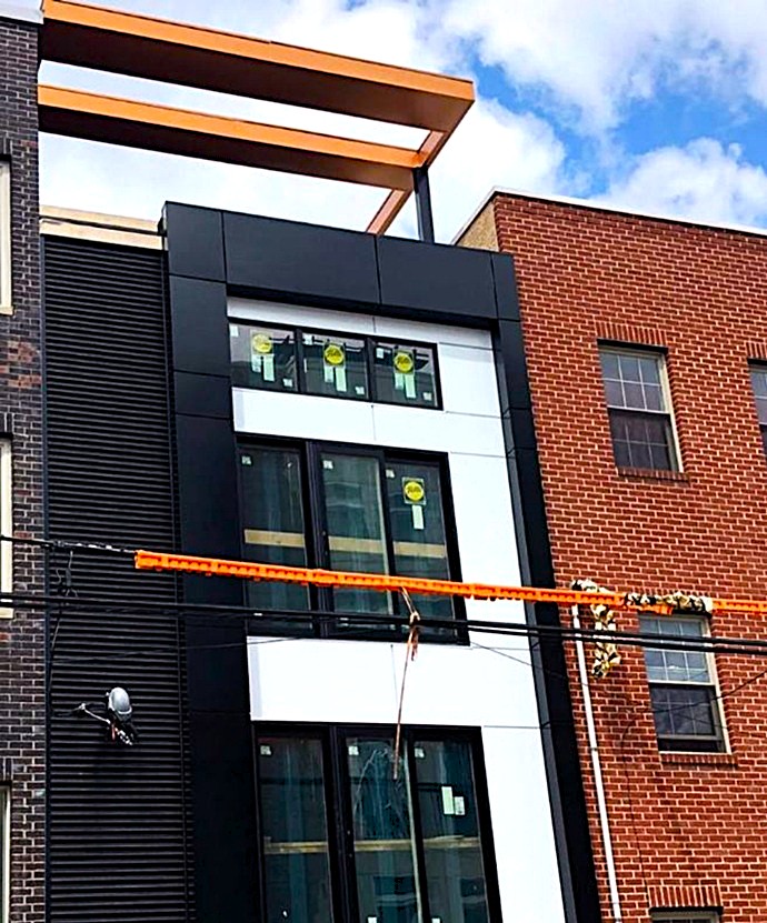 Fachada rehabilitada con diseño moderno y paneles eficientes en edificio residencial, ejemplo de renovación energética y estructural en entorno urbano.