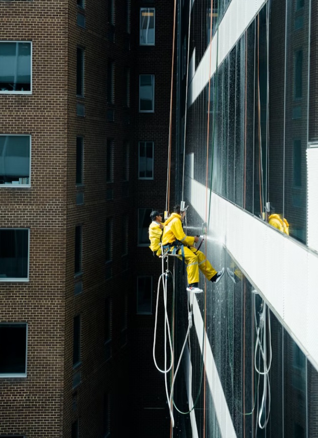 Técnicos especialistas en suspensión realizando limpieza de alta presión y chequeo de paramento vertical para prevenir patologías futuras.