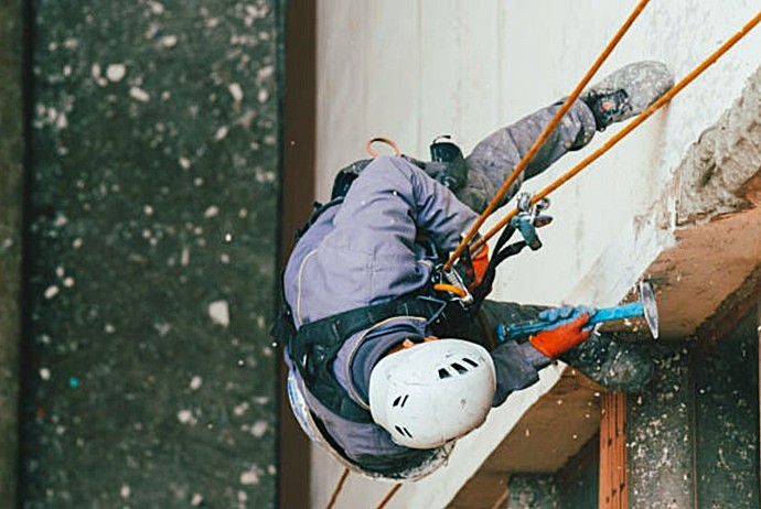 Técnico especialista de Europa 9 saneando fachada para reforzar la estructura de hormigón armado.