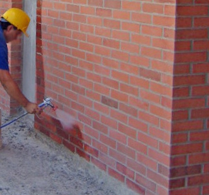 Efecto hidrófugo en Fachada vertical  en pleno tratamiento, donde el agua es repelida molecularmente sin formar película.