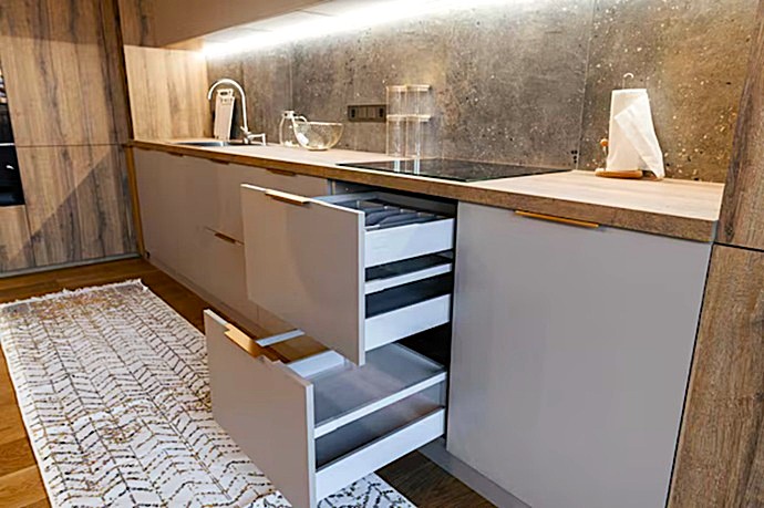 Instalación precisa de correderas cinéticas maximizando comodidad en obra de cocina actual.