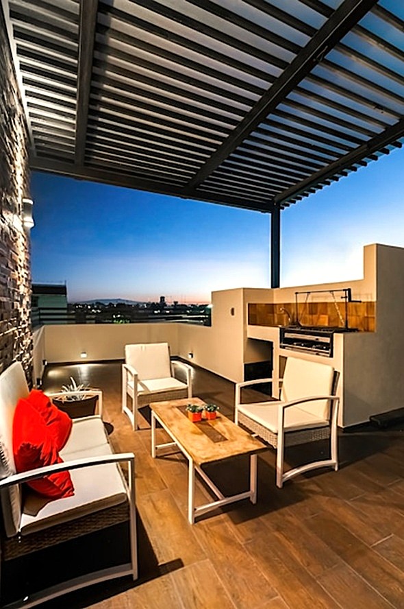 Terraza arreglada en piso alto de Valencia, apta para ocio con pérgola y zona de fuego.