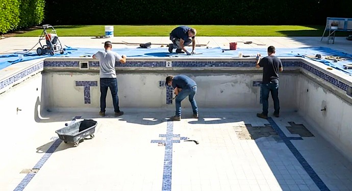 Operarios cualificados ejecutando la instalación de gresite y sellado técnico del vaso de piscina.