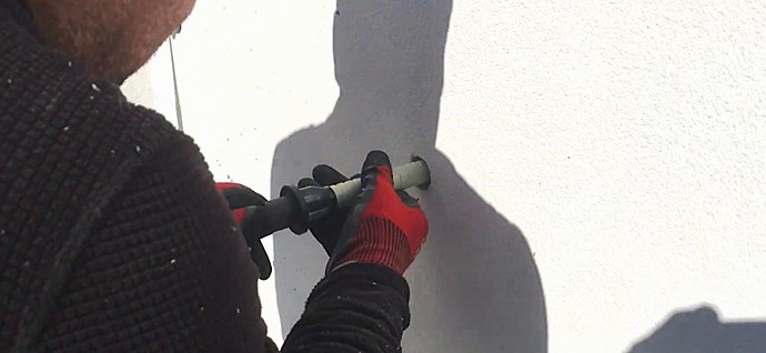 Instalación de malla técnica para refuerzo estructural de anclaje químico en paramento vertical.