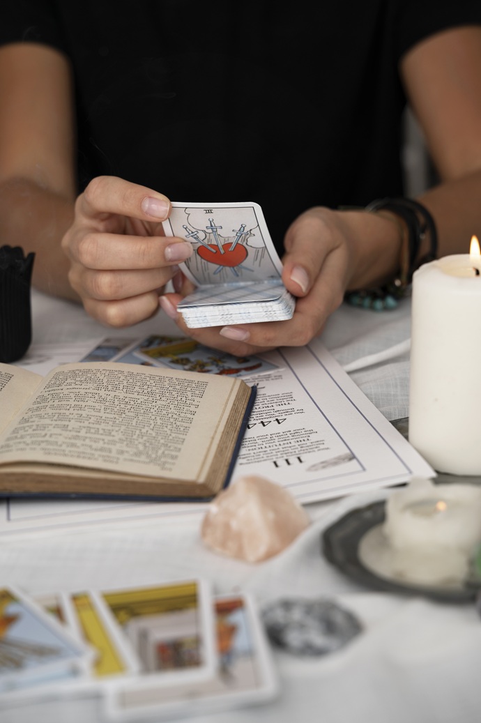 Manos de Aria Tarot barajando los arcanos en una sesión de cartomancia y numerología