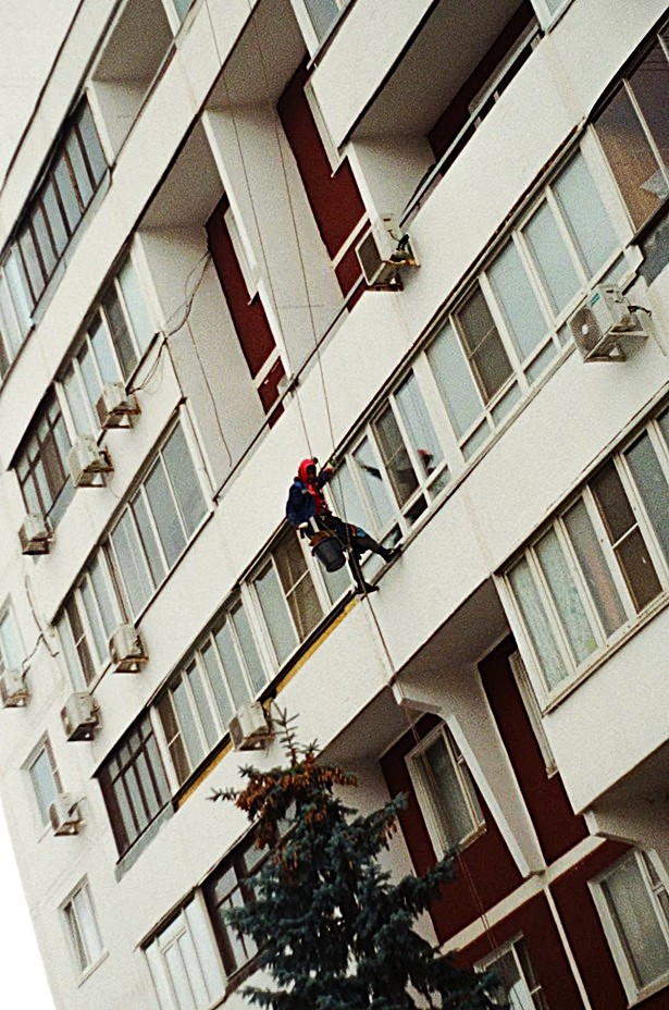 Especialista de Europa 9 en suspensión aplicando mortero de consolidación estructural en paramento exterior de fachada en Valencia.