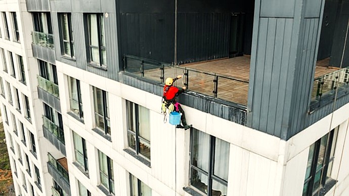 Fachada residencial de Valencia con técnico realizando labores verticales.