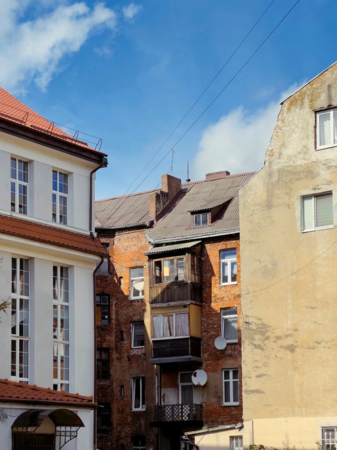 Fachada rehabilitada por Europa 9 contrastando con edificios degradados colindantes en Valencia, un antes y después técnico.