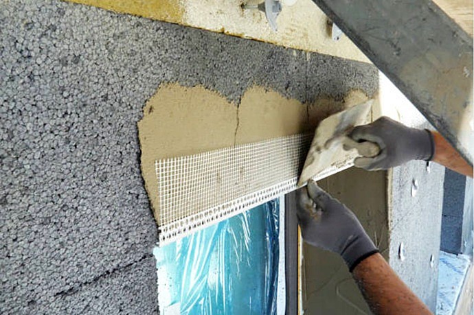 Especialista cualificado fundiendo la malla de refuerzo sobre la matriz del aislamiento.