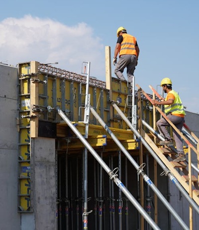 Técnicos cualificados realizando encofrado estructural con puntales de alta carga.