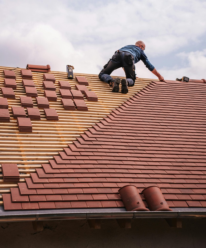 Técnico cualificado de Europa 9 instalando cobertura de teja cerámica sobre estructura de rastreles.