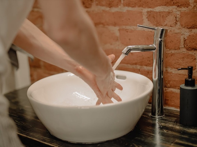 Usuario disfrutando de un flujo hídrico óptimo en su lavabo, síntoma de una instalación de fontanería saneada y libre de obstrucciones en el sur de Tenerife.