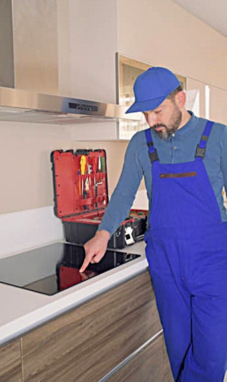 Técnico de Adisa diagnosticando el sistema de sensores Touch Control en placa de inducción.