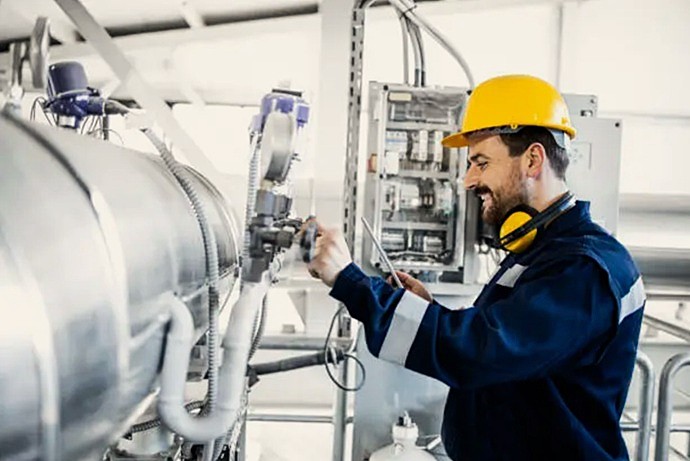 Técnico cualificado verificando presiones en generador térmico industrial mediante monitorización digital.