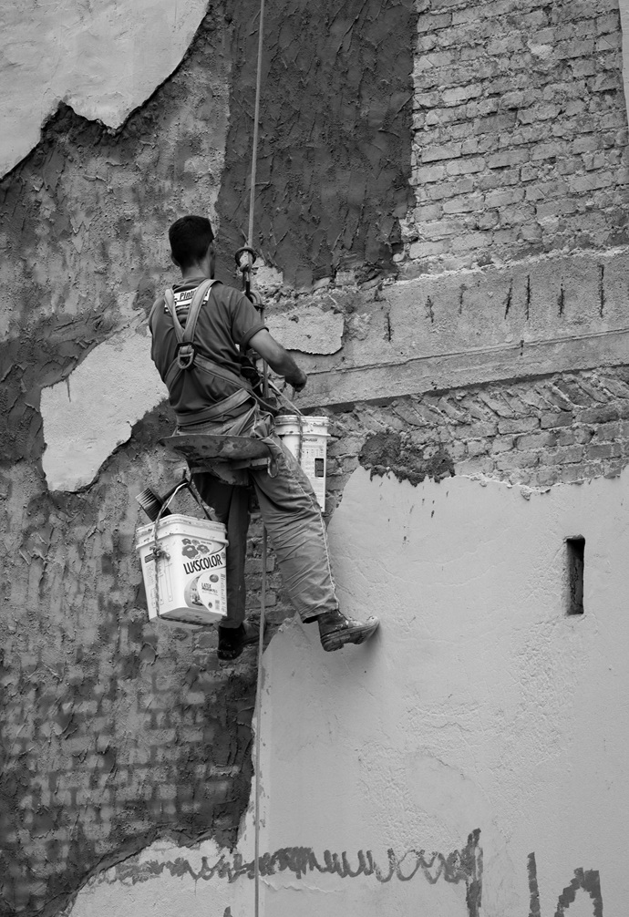 Técnico de Europa 9 realizando saneamiento manual del soporte y ladrillo visto mediante descuelgue vertical.