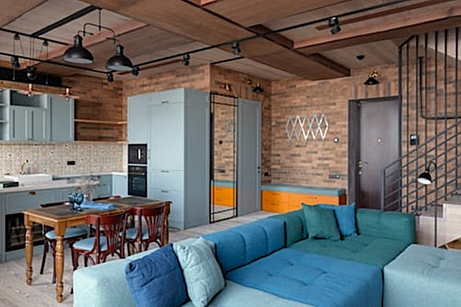 Interiorismo industrial refinado con vigas de madera y herrería técnica en Majadahonda.