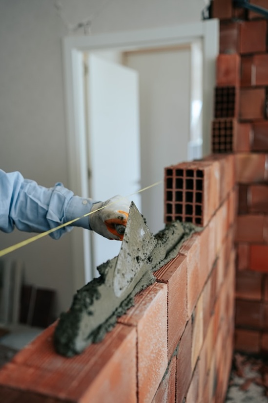 Especialista acreditado ejecutando nivelación en tabiquería estructural de ladrillo cerámico.