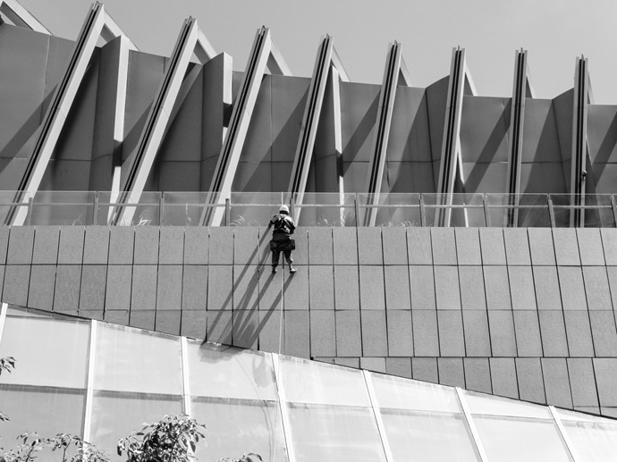 Maniobra de descuelgue vertical para el tratamiento preventivo de juntas en un edificio de diseño geométrico.