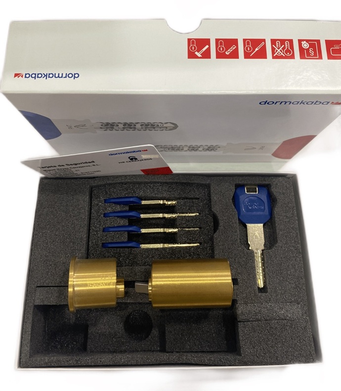Estuche de presentación de un sistema de cilindro Kaba Expert Plus en acabado latón con llaves de propietario, llave de servicio y tarjeta de propiedad.
