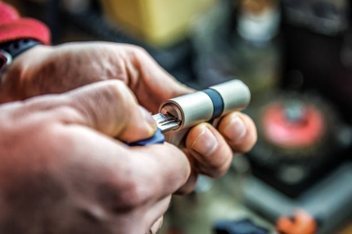 Técnico de Cerrajeros Técnicos examinando el giro de la llave en un bombín previo a su instalación en L'Antiga Esquerra de l'Eixample.