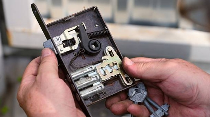 Técnico de cerrajería revisando el mecanismo interno oxidado de una cerradura de gorjas antigua en La Atunara.
