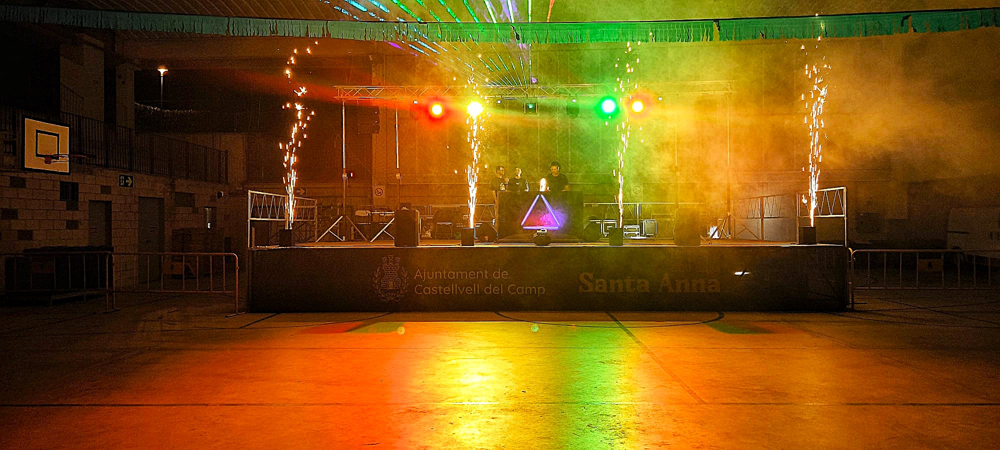 Montaje de escenario con efectos pirotécnicos fríos de titanio y control lumínico láser para festejos patronales de Santa Anna.