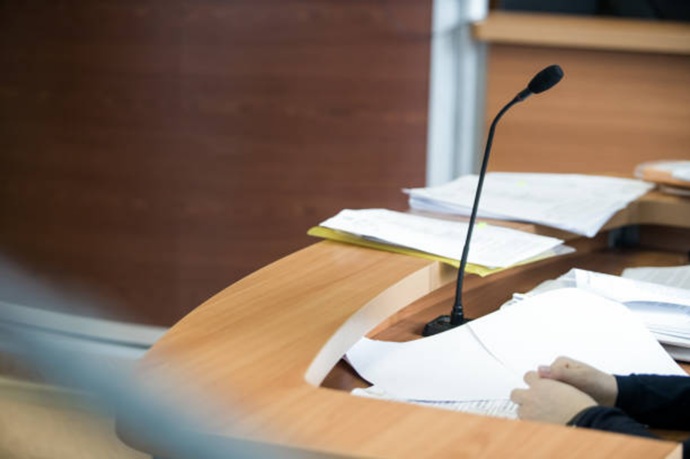 Micrófono en estrado judicial y documentación pericial para ratificación de informe de cerrajería forense