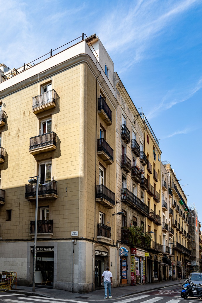 Esquina típica de Ciutat Vella con balcones tradicionales y accesos a ras de calle en el Raval.