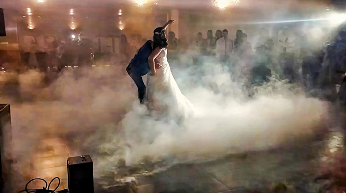 Discotecas Móviles Innovagroup operando máquina de humo bajo e iluminación puntual durante el baile nupcial de boda en La Selva del Camp